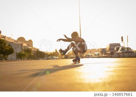 Person roller skating balancing skill during golden hour sunset Person roller skating balancing skill during golden hour sunset 140057661