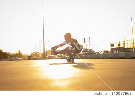 Woman balancing on roller skates during sunset in city Woman balancing on roller skates during sunset in city 140057662