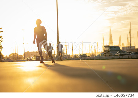 Woman rollerblading during sunset in urban port area Woman rollerblading during sunset in urban port area 140057734