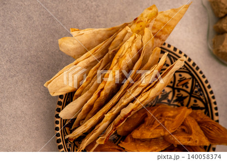Saudi Arabia food Mutabbaq - thin triangular envelopes of dough with filling fried in a pan. Flatbread is a traditional Arabic food. 140058374
