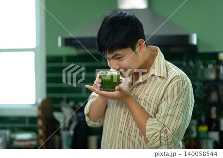 Man enjoying aroma of homemade matcha in kitchen 140058544