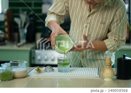 Cropped shot man adding fresh matcha to glass Cropped shot man adding fresh matcha to glass 140058568