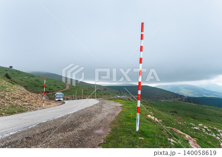 Mountain road with snow poles under storm clouds in Catalan Pyrenees Mountain road with snow poles under storm clouds in Catalan Pyrenees 140058619