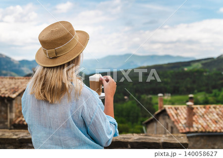 Woman with cappuccino enjoying peaceful countryside and mountain panorama Woman with cappuccino enjoying peaceful countryside and mountain panorama 140058627