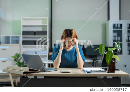 Tired asian businesswoman with headache at office, feeling sick at work. Tired asian businesswoman with headache at office, feeling sick at work. 140058717