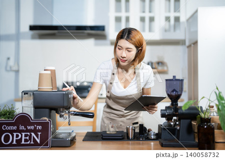 Female barista checking coffee machine equipment. Female barista checking coffee machine equipment. 140058732