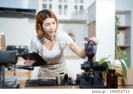 Female barista checking coffee machine equipment. Female barista checking coffee machine equipment. 140058733