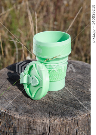 Eco-friendly folding cup stands on a wooden stump Eco-friendly folding cup stands on a wooden stump 140059219