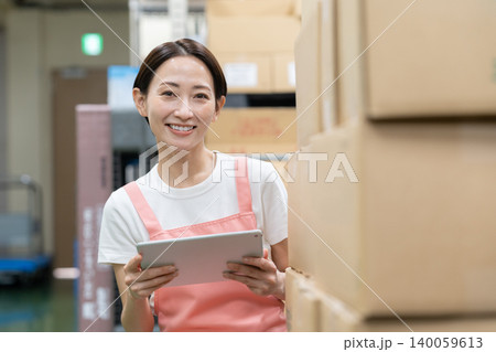 倉庫で働くミドルの女性作業員 倉庫で働くミドルの女性作業員 140059613