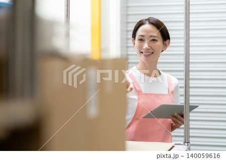 倉庫で働くミドルの女性作業員 倉庫で働くミドルの女性作業員 140059616
