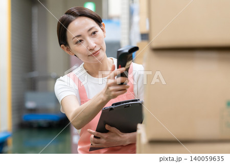 倉庫で働くミドルの女性作業員 倉庫で働くミドルの女性作業員 140059635