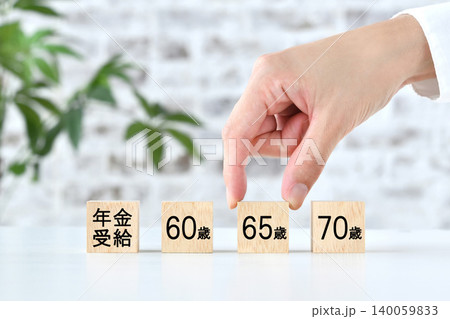65歳での年金の受給年齢を選択する人物の手 140059833