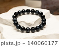 Natural stone blue tiger eye bracelet rests on white rock surface 140060177