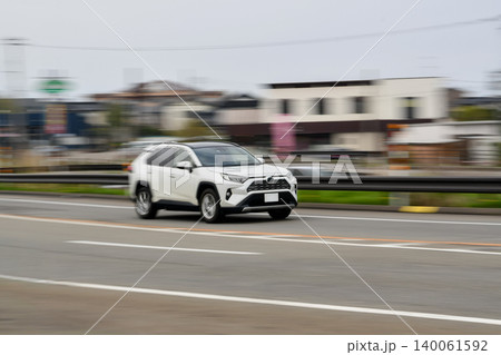 郊外の道路を走行するSUVの流し撮り写真 140061592