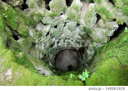 High angle view looking down the mossy stone Initiation Well of Quinta da Regaleira in Sintra, Portugal High angle view looking down the mossy stone Initiation Well of Quinta da Regaleira in Sintra, Portugal 140061929
