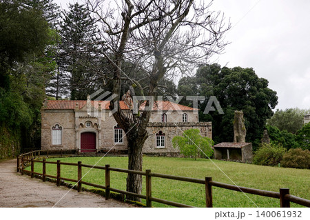 Beautiful stone estate building with a green lawn and wooden fence at Quinta da Regaleira in Sintra, Portugal 140061932