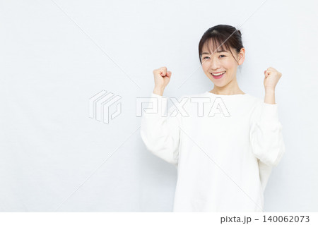 笑顔でガッツポーズをしている女性 笑顔でガッツポーズをしている女性 140062073