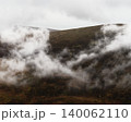 The tops of mountains are veiled by ethereal white mist. 140062110