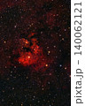 A spectacular cosmic display unfolds in the night sky, with a glowing red emission nebula, intricate dark dust lanes and countless brilliant stars. 140062121