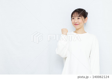 笑顔でガッツポーズをしている女性 笑顔でガッツポーズをしている女性 140062124