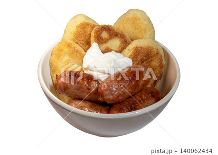 Traditional Ukrainian meal with sausages, potato pancakes, sour cream garnish 140062434