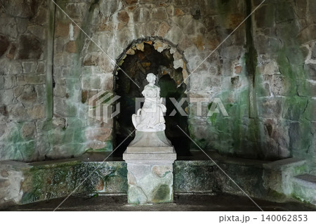 White marble female statue inside a mossy stone grotto at Quinta da Regaleira in Sintra, Portugal 140062853