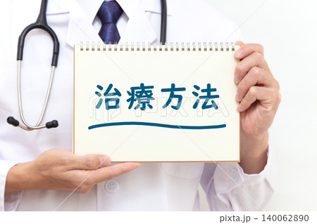 治療方法を書かれたノートを持つ日本人男性ドクターの手元 140062890