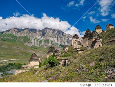 Ancient stone crypts on a green mountain slope in the City of the Dead Dargavs, Russia Ancient stone crypts on a green mountain slope in the City of the Dead Dargavs, Russia 140063984