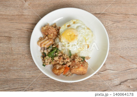 spicy chili fried chop pork and tofu couple basil topping rice dressing egg on plate spicy chili fried chop pork and tofu couple basil topping rice dressing egg on plate 140064178