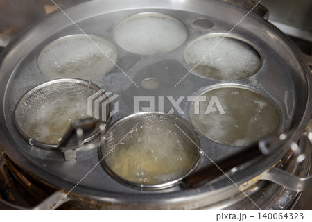町中華の茹で釜でテボで麺を茹でる風景 町中華の茹で釜でテボで麺を茹でる風景 140064323