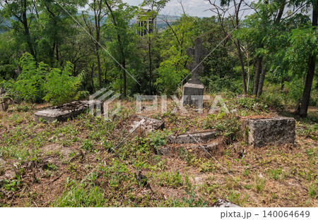 Old graveyard with tombstones and greenery in a rural location during daylight hours Old graveyard with tombstones and greenery in a rural location during daylight hours 140064649