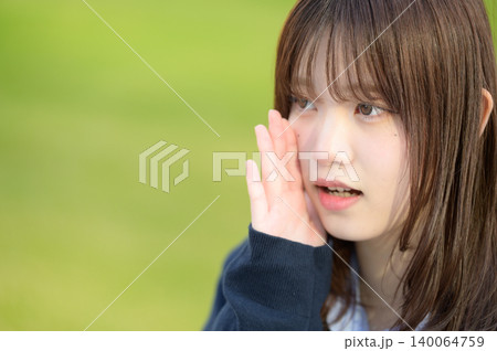 芝生の前で話しかける日本人女子高生 140064759