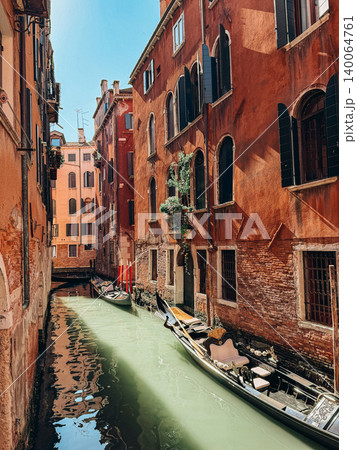 Sunny Venetian Canal With Traditional Stone Bridge and Old Buildings Sunny Venetian Canal With Traditional Stone Bridge and Old Buildings 140064761