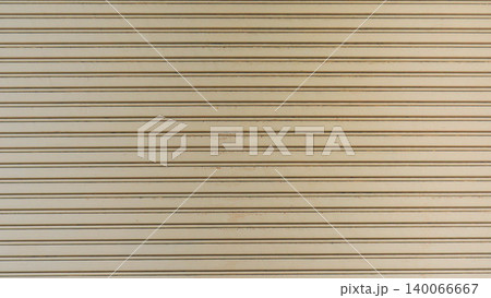 Beige metal roller shutter door texture background. Horizontal lines on steel rolling garage surface. Beige metal roller shutter door texture background. Horizontal lines on steel rolling garage surface. 140066667
