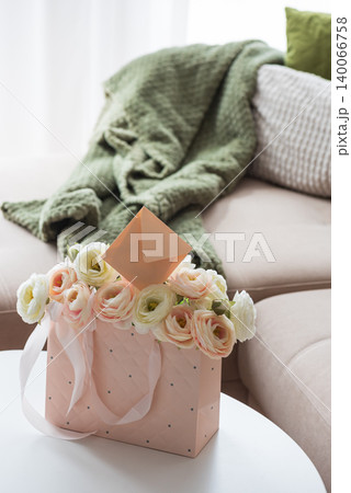 Ranunculus Bouquet with Gift Bag and Envelope in Cozy Living Room Ranunculus Bouquet with Gift Bag and Envelope in Cozy Living Room 140066758