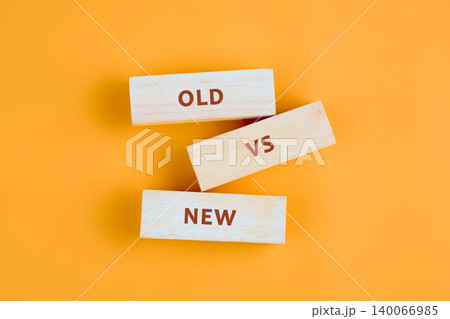 Three light wood blocks rest on an orange background. The blocks spell out OLD VS NEW, clearly illustrating the concept of comparing old and new ideas or methods Three light wood blocks rest on an orange background. The blocks spell out OLD VS NEW, clearly illustrating the concept of comparing old and new ideas or methods 140066985