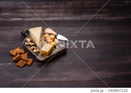 Aged cheese in a triangular block with jam, figs, and nuts. Aged cheese Aged cheese in a triangular block with jam, figs, and nuts. Aged cheese 140067226