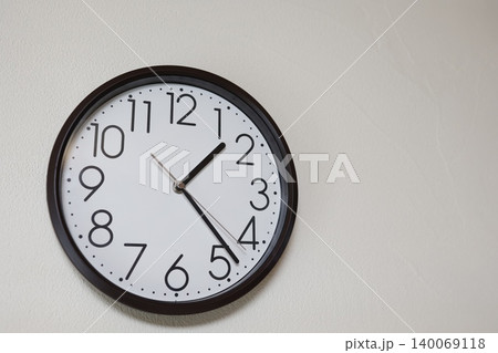 アナログ時計。13時半前または1時半前を示す。黒い枠。白い文字盤 140069118