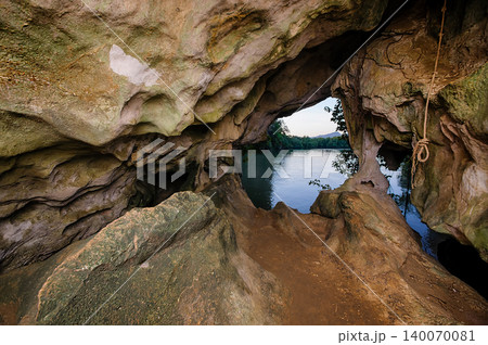a cave with stalagmites and stalactites. The cave is large and dark, and the walls are covered in a variety of different rock formations. The stalagmites and stalactites are a variety of shapes and a cave with stalagmites and stalactites. The cave is large and dark, and the walls are covered in a variety of different rock formations. The stalagmites and stalactites are a variety of shapes and 140070081