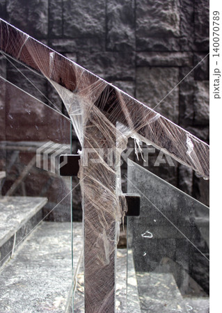 Wooden handrail with glass barrier wrapped in protective plastic. Wooden handrail with glass barrier wrapped in protective plastic. 140070789