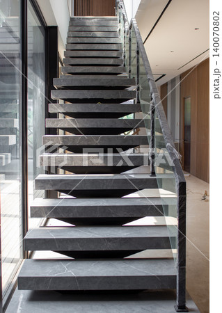 Modern floating stairs using grey marble with glass railing. Modern floating stairs using grey marble with glass railing. 140070802