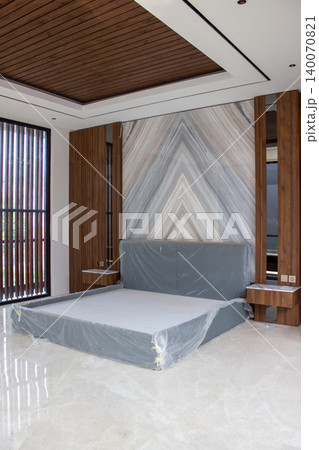 Bed wrapped in plastic protection with statuario marble wall panel. 140070821