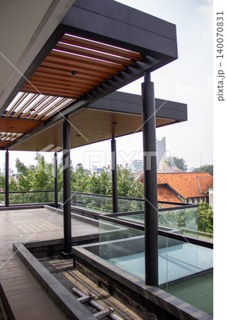 Upper floor open balcony using round black column and wood canopy. 140070831