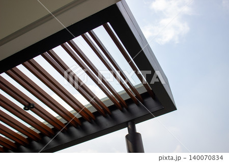 Modern canopy corner combining black iron frame and wood louvers. Modern canopy corner combining black iron frame and wood louvers. 140070834