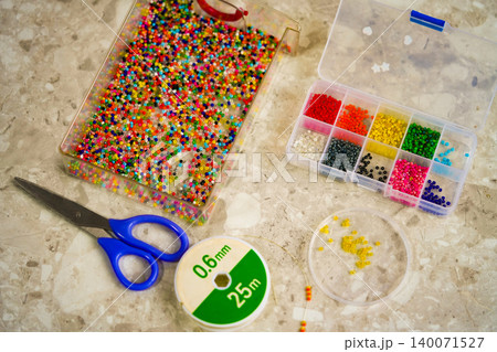 Close up of colorful seed beads in square sections pink shades, flat lay Close up of colorful seed beads in square sections pink shades, flat lay 140071527