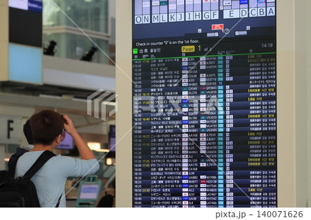 空港の時刻表を確認する旅行客 国際線の時刻表 空港の時刻表を確認する旅行客 国際線の時刻表 140071626
