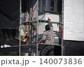 家の側壁を塗り直し作業をする様子 140073836