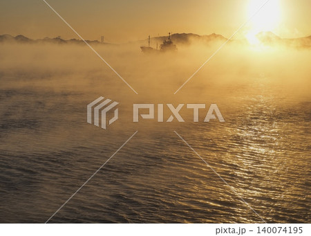 朝日に照らされた海霧の中を行く船 朝日に照らされた海霧の中を行く船 140074195