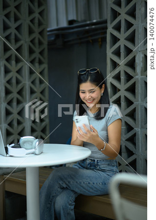 Businesswoman using smartphone at outdoor cafe workspace Businesswoman using smartphone at outdoor cafe workspace 140074476