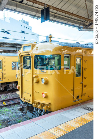 Yellow commuter train at railway station platform in Japan 140074765